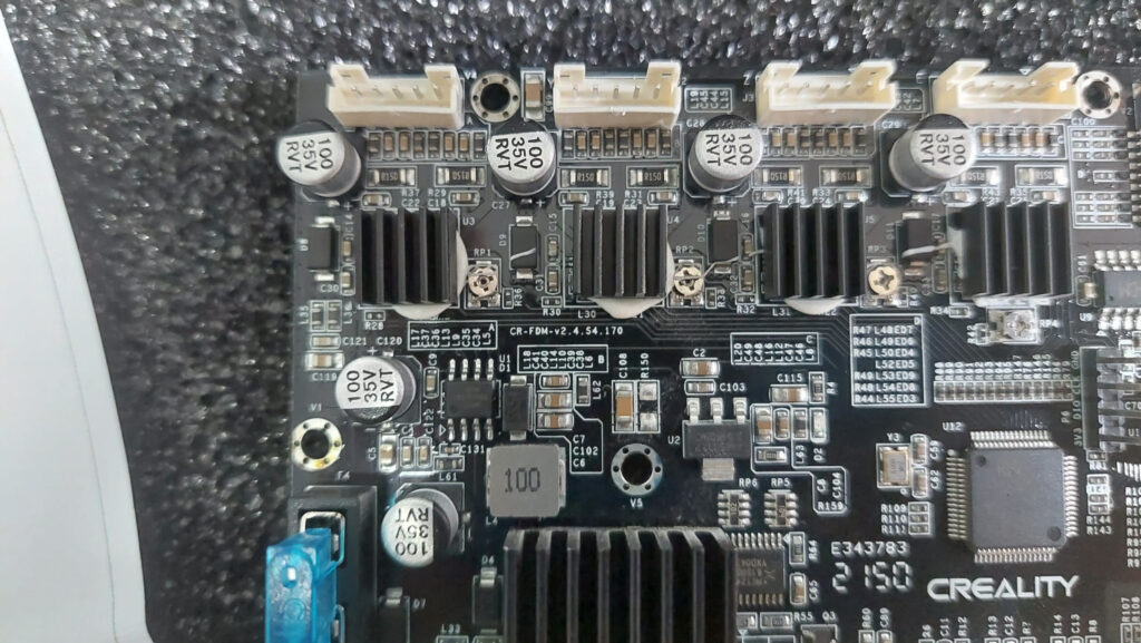 Stock Creality CR-FDM-v2.4.S4.170 mainboard with four stepper driver heatsinks, seated in foam