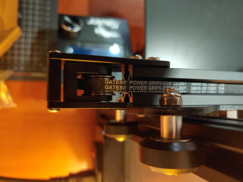 Gates belt looped through an aluminium belt tensioner at the end of a printer's frame extrusion