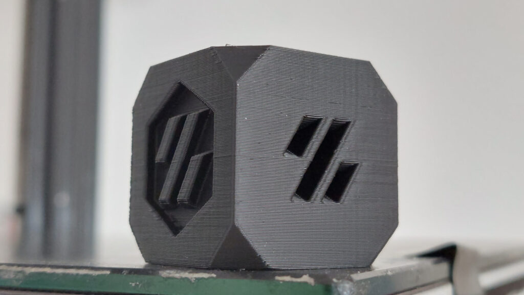 3D Printer Belt Tension: 3 Ways to Measure and the Best One to Trust 7 Close-up of a black 3D printed test cube with sharp edges and even layer lines