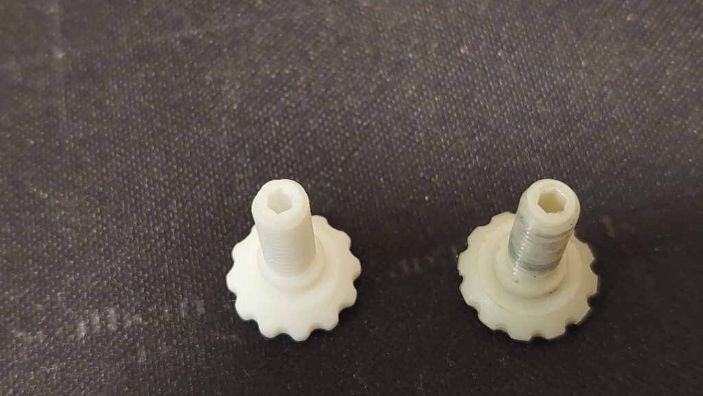 3D printed threads test: two white printed threaded knobs with scalloped bases and hex sockets, the right one's thread visibly different