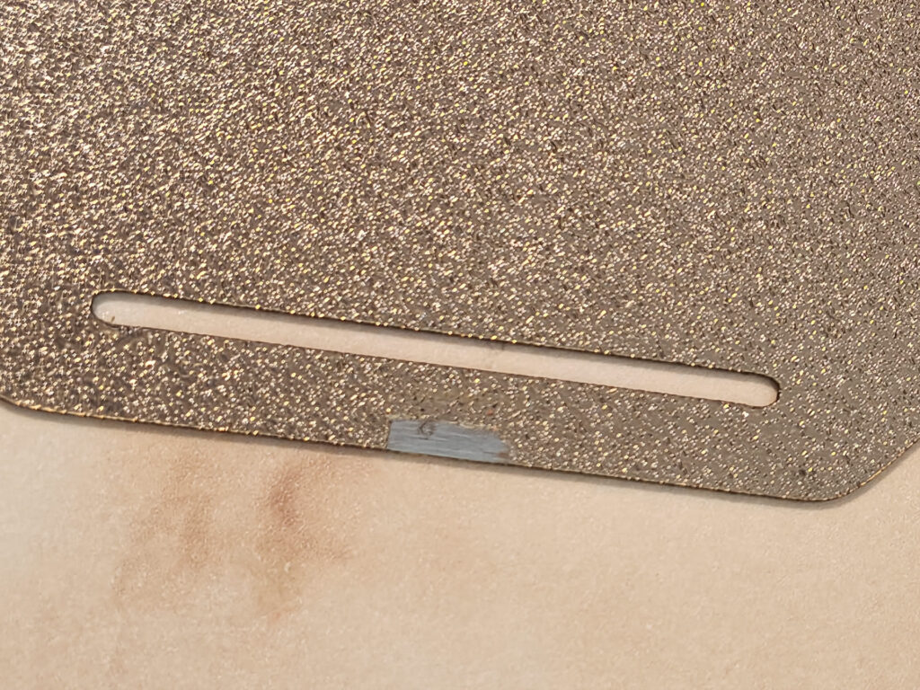 Textured PEI build plate of the printer in this Bambu Lab P1S review, with a grey patch worn beside its slot by the nozzle